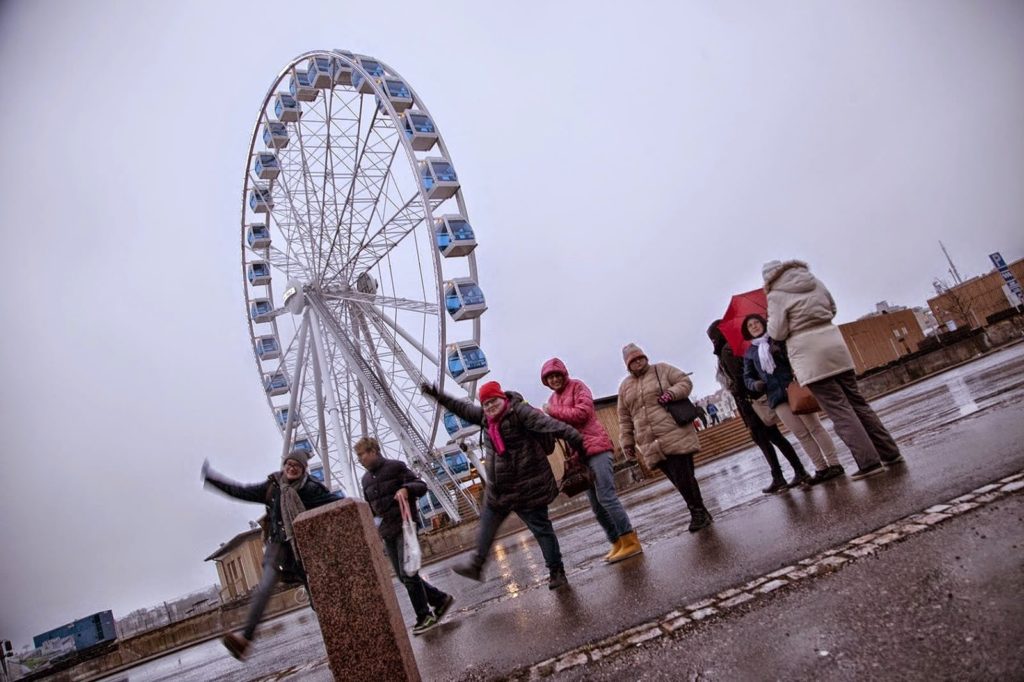 A group of happy people in front of a ferris wheel
